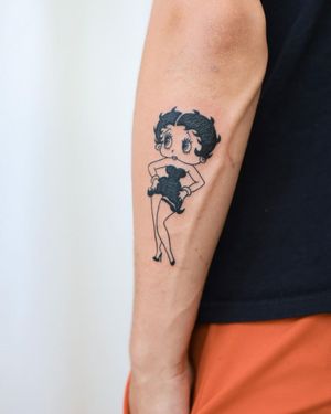 Captivating blackwork forearm tattoo featuring Betty Boop-inspired woman with elegant earrings, done by renowned artist Steven Brooks.
