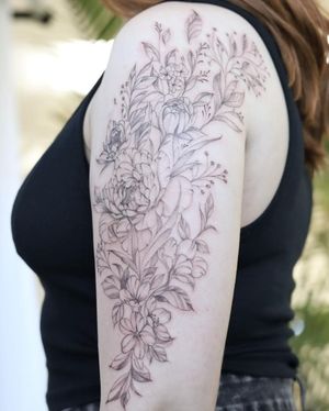 Express your beauty with this illustrative fine line flower tattoo on your upper arm. Delicate and striking, this design by Palena is sure to turn heads.