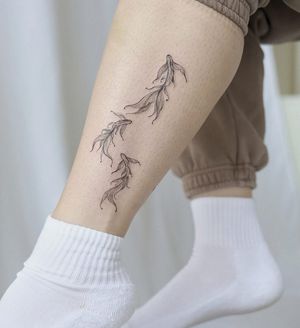 Get a beautifully detailed fish tattoo on your ankle with delicate fine line work by Palena, a master of illustrative style.