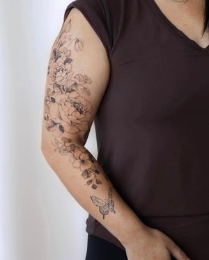 Beautiful blackwork flower tattoo by Sasha Sunshine on a sleeve. Detailed and intricate design.