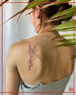 Discover the beauty of fine line and illustrative style with this stunning hummingbird tattoo by Tianna. Perfect for your upper back!