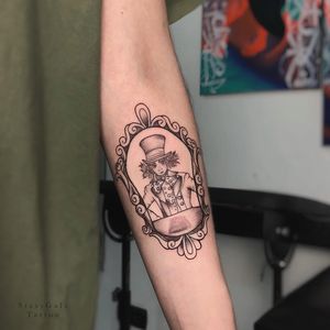 Unique blackwork forearm tattoo featuring a detailed man in a hat framed in fine line style by Stasy Galz.