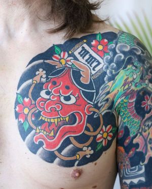 Unique chest piece featuring a powerful dragon, beautiful flower, hannya mask, meaningful quote in kanji, expertly done by Leo Quintao.