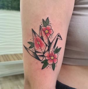 Stunning illustrative design by Liza Vettaa, featuring a vibrant cherry blossom and graceful crane on upper arm.