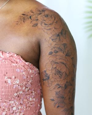 Get a stunning blackwork flower tattoo on your upper arm by Sasha Sunshine for a unique and artistic look.