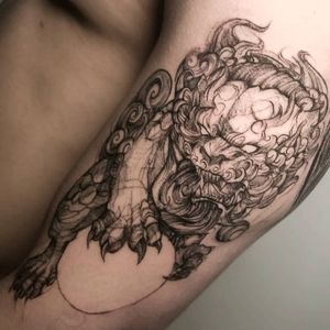 Get an intricate blackwork foo dog tattoo on your upper arm by the talented artist Inkcognito. Perfect for those who appreciate Japanese art!