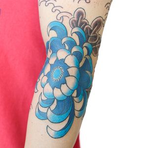 Experience the beauty of traditional Japanese art with this illustrative flower tattoo on your arm by the talented Leo Quintao.