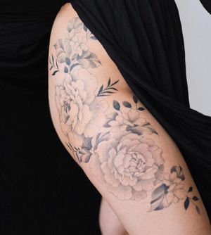 Elegant black and gray flower tattoo by Yasmin Clara, skillfully done on the upper leg. A stunning addition to your body art collection.