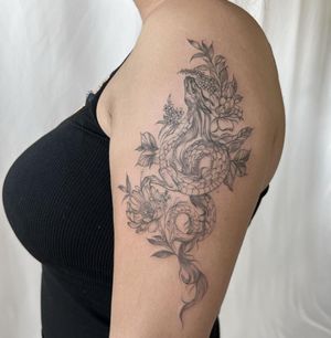 A striking blackwork tattoo featuring a dragon intertwined with a delicate flower, expertly done by Palena. Perfect for those who appreciate illustrative designs.