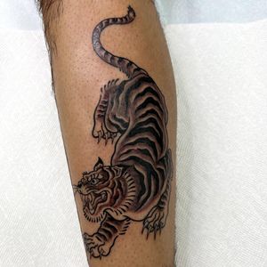 This illustrative Japanese tiger tattoo by Leo Quintao is a fierce and stylish addition to your lower leg. Let your wild side roar!