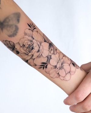 Elegant blackwork design by Sasha Sunshine, featuring a stunning and intricate flower motif on the forearm.