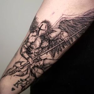 This blackwork forearm tattoo features an angel in helmet with wings and spear, by the talented Inkcognito.