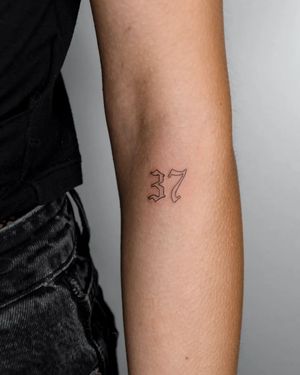 Get a stylish and sophisticated tattoo of your favorite number on your forearm by Kateryna Tytarenko. Perfect for those who appreciate small lettering and fine line work.