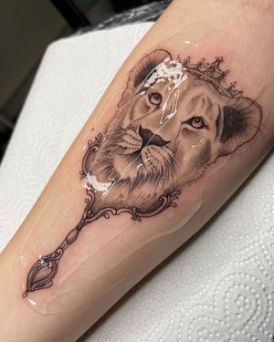 Adorn your forearm with a stunning blackwork and realistic lioness wearing a crown, symbolizing strength and royalty. Expertly crafted by Stasy Galz.