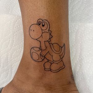 Adorn your ankle with Nicole Ksiazek's illustrative design featuring a cute turtle and iconic video game character, Yoshi.