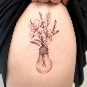 Embrace the beauty of nature with Yasmin Clara's illustrative blackwork tattoo featuring a stunning flower bulb on your back.