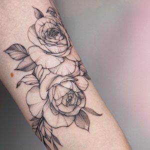 Elegant blackwork illustration of a flower on the forearm by Irene Bogachuk. Perfect blend of fine lines and intricate details.