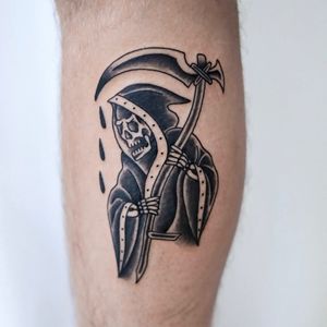 Bold blackwork traditional tattoo of the Grim Reaper wielding a scythe, expertly done on lower leg by Jenna Jeep.