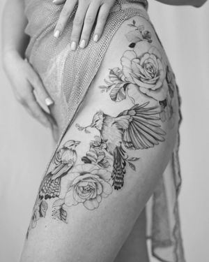 Unique blackwork design on upper leg by Sasha Sunshine, featuring a bird and flower motif.