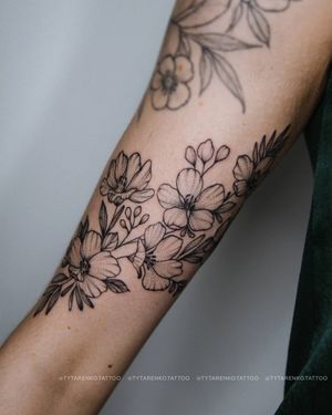 Elegant blackwork flower tattoo on forearm by Kateryna Tytarenko. Detailed and stylish design.