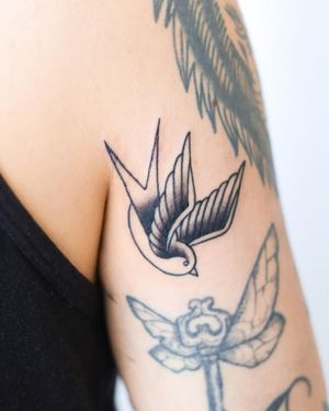 Get a stunning blackwork bird tattoo on your upper arm by talented artist Steven Brooks. Embrace a classic traditional style with this unique design.