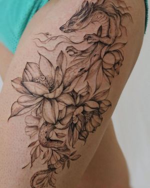 Unique blackwork illustrative design of a dragon intertwined with a flower, executed by Palena on the upper leg.