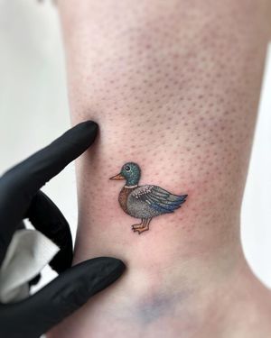 Get a whimsical tattoo of a duck on your ankle by the talented artist Vic. Perfect for animal lovers and nature enthusiasts.