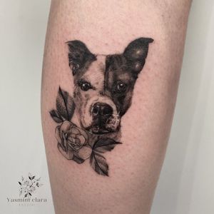 Unique blackwork tattoo featuring a lifelike dog and intricate flower design, by talented artist Yasmin Clara.