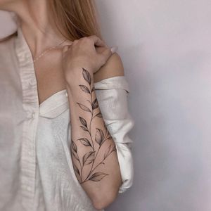 Exquisite blackwork leaf tattoo by Irene Bogachuk, beautifully rendered on the forearm for a striking look.