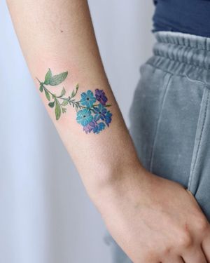 Get a stunning illustrative watercolor flower tattoo on your forearm by the talented artist Cerf. Stand out with this vibrant and unique design.