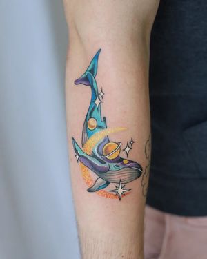 Unique neo traditional forearm tattoo by Liza Vettaa featuring a majestic whale swimming around a planet in illustrative style.