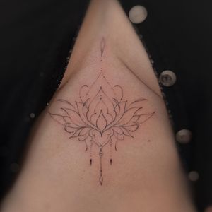 Elegant blackwork mandala with fine line geometric and ornamental details, creating a mesmerizing pattern under the boob.