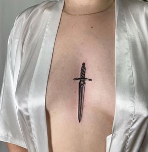 Check out this blackwork sword tattoo by Jenna Jeep for a bold and unique sternum piece.