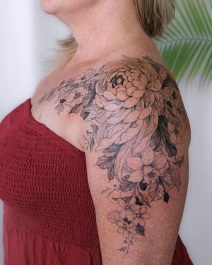 Elegant blackwork flower tattoo on shoulder by artist Sasha Sunshine, perfect for nature lovers.