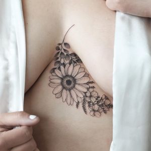 Beautiful blackwork flower tattoo on sternum by Yasmin Clara, featuring intricate illustrative design.