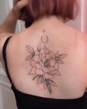 Irene Bogachuk's intricate blackwork design featuring a geometric moon, flower, and pattern on the upper back.