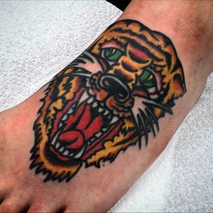Roar into style with this fierce traditional tiger tattoo by Alessandro Lanzafame on your foot.