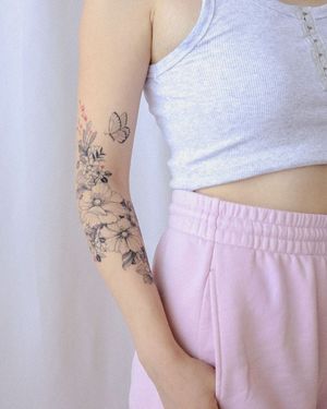 Elegant fine line illustration by Sasha Sunshine, featuring a beautiful butterfly and flower motif on the arm.