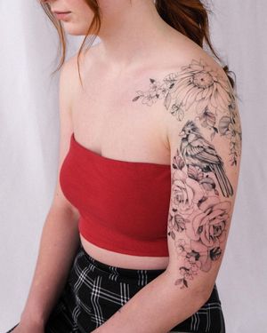 Beautiful blackwork design by Sasha Sunshine featuring a bird and flower motif on the arm.