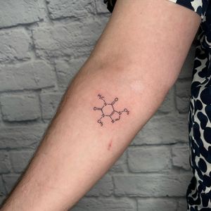 Elegant fine line tattoo on forearm by Jenna Jeep. Features intertwined DNA chain with small lettering of a meaningful quote.