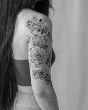 Beautiful blackwork flower tattoo on upper arm by artist Sasha Sunshine.