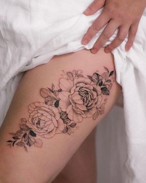 Beautiful blackwork flower tattoo on upper leg, inked by Sasha Sunshine. A stunning and unique piece of body art.