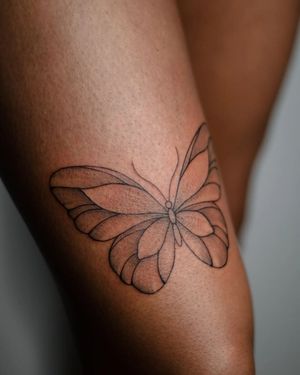 Transform your upper leg with a stunning blackwork butterfly design by Kateryna Tytarenko.