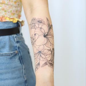 Stunning flower tattoo by Yasmin Clara showcasing intricate blackwork design on forearm.