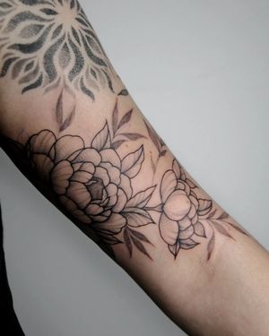 Get a beautiful illustrative blackwork flower tattoo on your arm by the talented artist Kateryna Tytarenko.