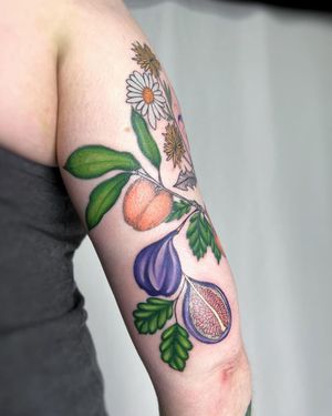 Vibrant and detailed fruit tattoo of a pomegranate on the upper arm by talented artist Vic. Perfect blend of color and linework.