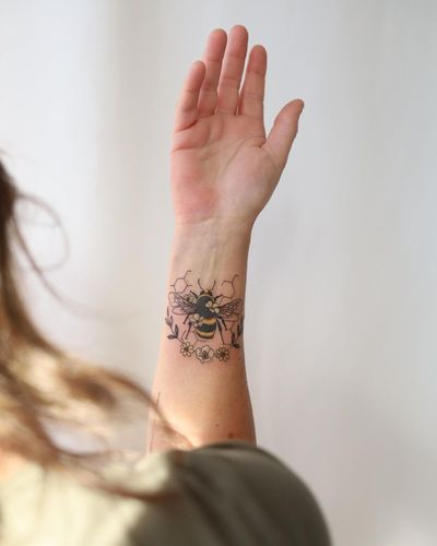 Beautiful illustrative tattoo design by Cerf featuring a bee and a flower, perfect for your forearm.