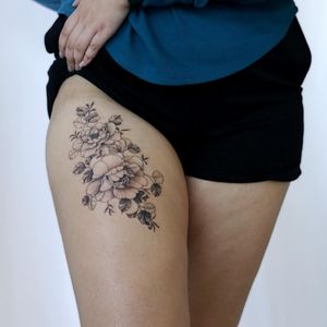 Beautiful blackwork flower tattoo on the upper leg by Yasmin Clara, combining detailed line work with bold shading.