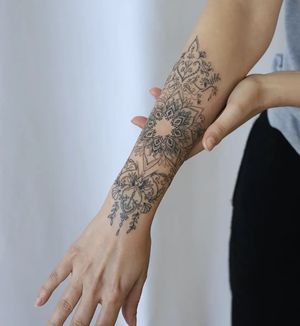 Adorn your forearm with a stunning blackwork mandala design by the talented artist Liza Vettaa. Combining fine line details and ornamental elements, this tattoo is sure to make a statement.