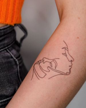 Exquisite fine line tattoo featuring the faces of a woman and a man, created by the talented artist Kateryna Tytarenko.